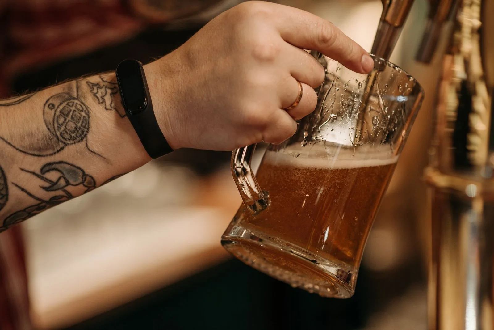 A glass of beer being pulled from a draft tap